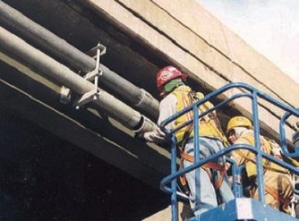 Engineers on a blue lift working on a fiberglass conduit.